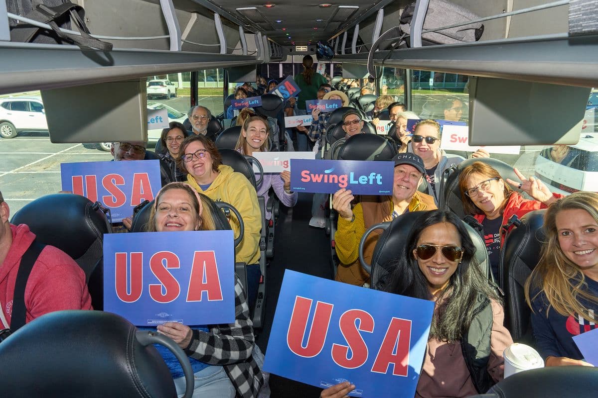 Swing Left Volunteers on a bus with signs